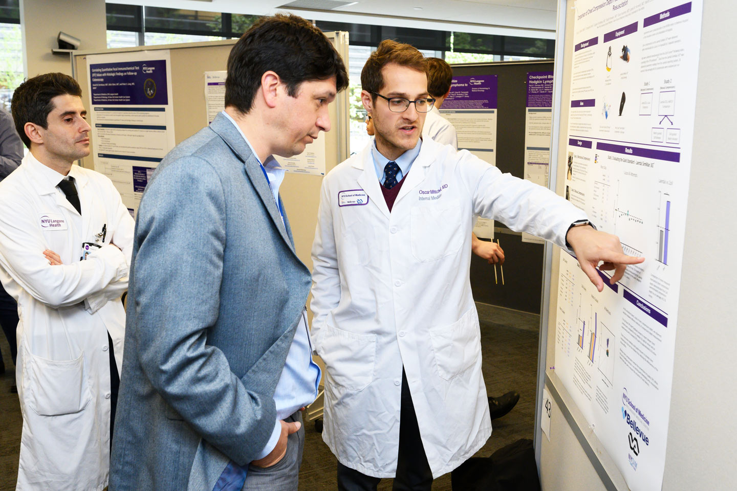 Two Doctors Discuss a Poster During Research Day